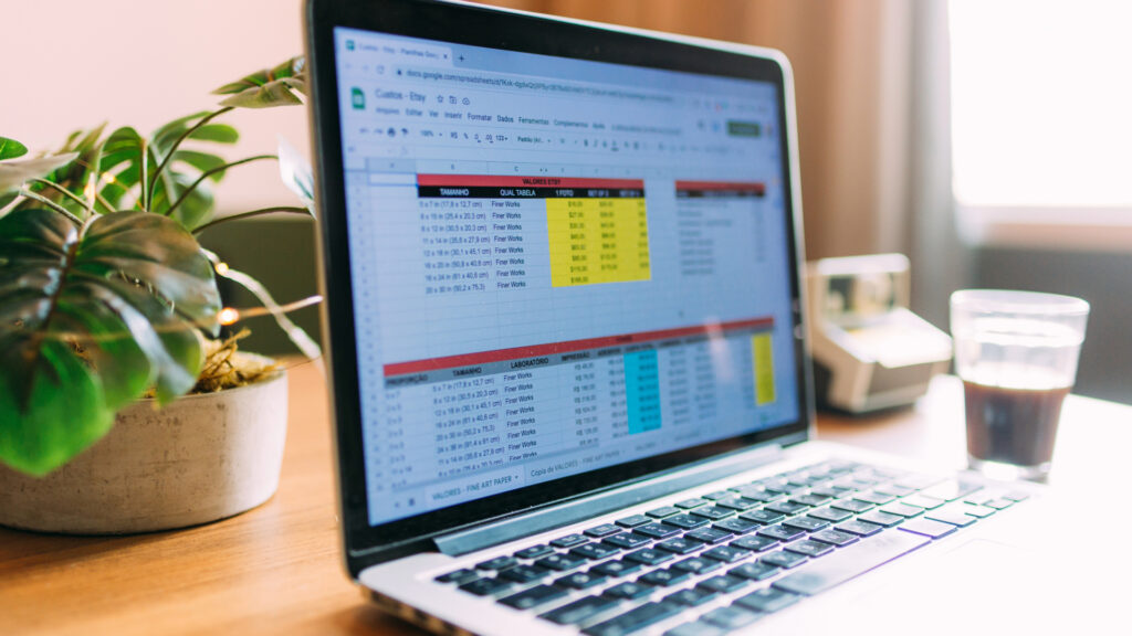 Open laptop on a wooden table displaying a spreadsheet.