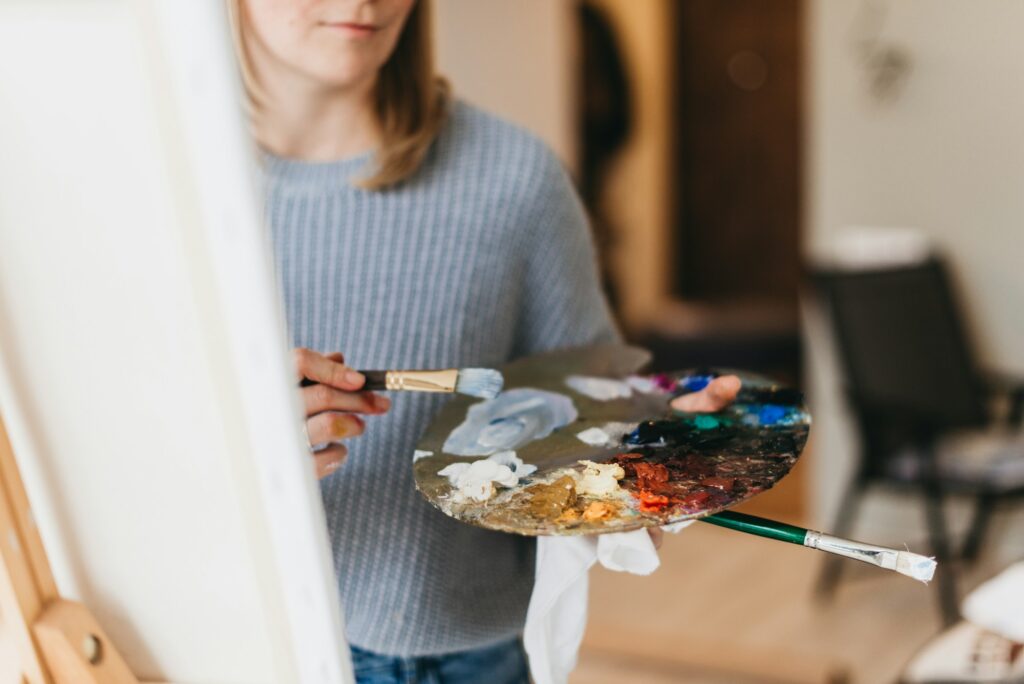 The palette of paints in the hands of the artist