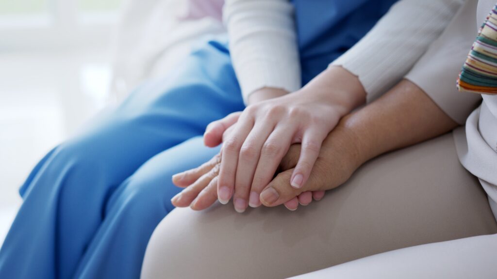 Close up hand of young woman or nurse home care holding senior grandmother