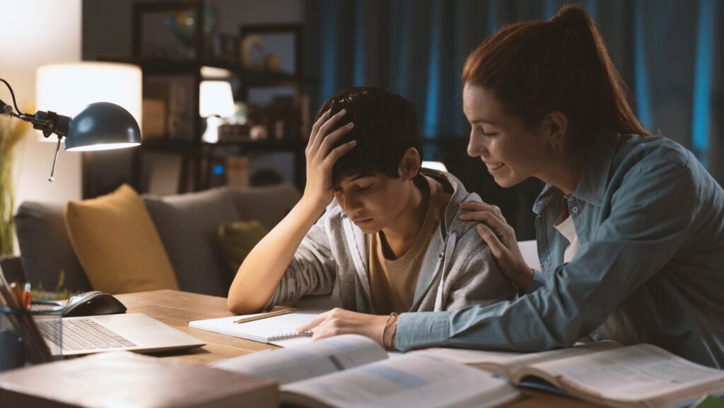 Sister helping her younger brother with his homework