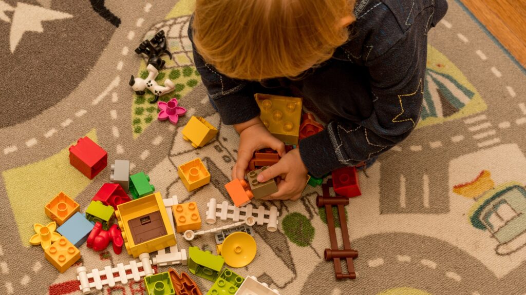 Toddler boy playing with construction blocks. Early development childcare preschool